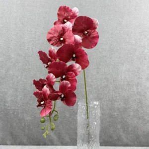 Gedetailleerde close-up van een kunstmatige phalaenopsis orchideeëntak in een glazen vaas.