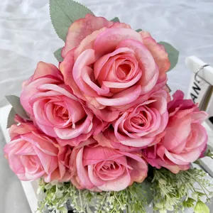 Dettaglio in primo piano di bouquet di rose in seta artificiale rosa con foglie per decorazione.