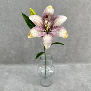 Close-up detail of artificial lily flower with realistic petals and clear glass vase stem decor.