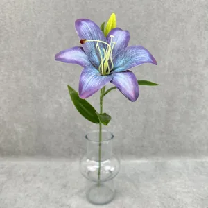 Detailed view of a single artificial purple lily flower placed inside a clear glass vase.
