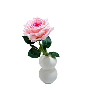 Artificial pink rose flower with white ceramic vase for home decor, wedding and photography.