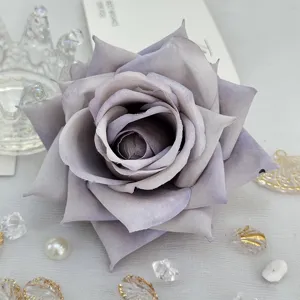 Detailed view of artificial rose flower head, grey purple fabric flower for DIY crafts.