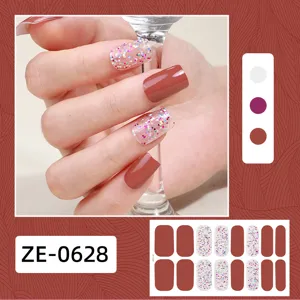 Vista dettagliata di adesivi per unghie 3D glitterati e rosso marrone, manicure elegante.