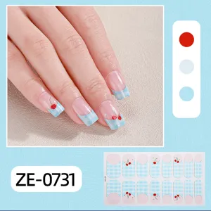 Close-up detail showing blue plaid cherry nail wraps applied on hand with full sheet display.