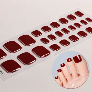 Dettaglio di adesivi per unghie dei piedi in gel semi-polimerizzato rosso scuro.