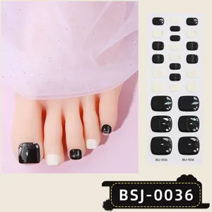 Semi-cured gel toenail wraps with black, white glitter and rhinestone designs for chic pedicures.