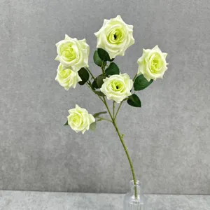 Vue détaillée de la branche de roses vertes artificielles avec têtes multiples pour le décor.