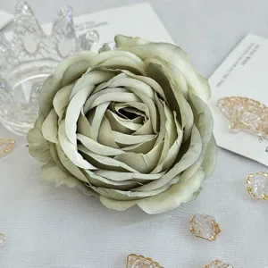 Gros plan détaillé d'une tête de rose artificielle vert sauge bouclée pour la décoration.