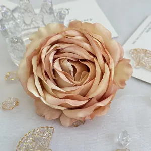 Gros plan détaillé d'une tête de rose artificielle en tissu avec dégradé et bords enroulés.
