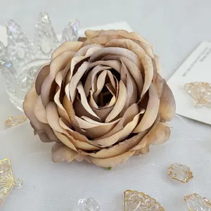 Gros plan tête de rose en tissu marron artificiel pour déco de mariage et accessoires de boîte-cadeau.