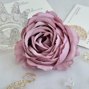 Gros plan détail de tête de fleur de rose mauve artificielle, accessoire de mariage.