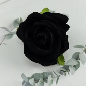 Black velvet artificial rose flower head with green leaves for wedding decor and photography props.