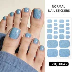 Primo piano dettagliato di adesivi per unghie dei piedi con glitter blu brillante.