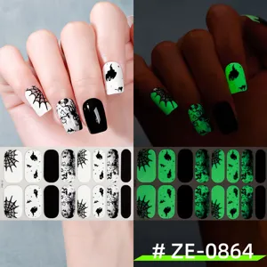 Detailed view of Halloween glow-in-the-dark nail wraps featuring spooky ghost and spider web designs.