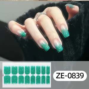 Close-up detail of sparkly green gradient nail wraps on hand model with sticker sheet view.
