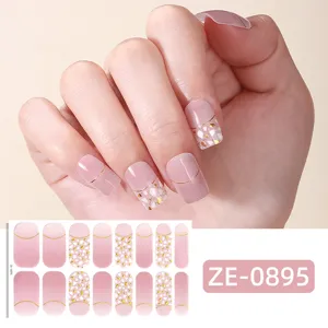 Strisce per unghie sfumate rosa con linee dorate e glitter per una manicure elegante.