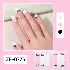 Close up details of pink and white french press on nail stickers with cute black bow designs.