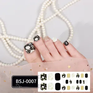 Semi-cured gel toe nail wraps with black floral and gold glitter design for women pedicure art.