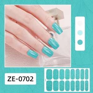 Détail des bandes de vernis à ongles bleu pailleté montrant des stickers nail art étincelants.