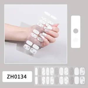 Vista de detalle en primer plano de pegatinas de uñas con copos de nieve brillantes.