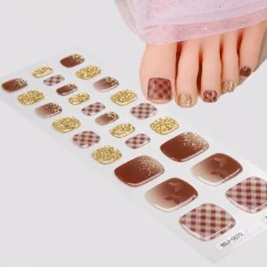 Adesivi per unghie dei piedi in gel UV semi-polimerizzato con motivi a quadretti marroni e glitter.