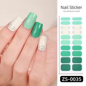 Close-up view of green gradient nail stickers with cute dog pattern on hand model sheet.