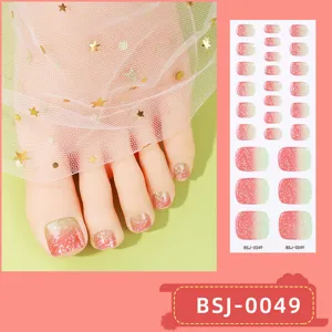 Close-up detail of gradient glitter toe nail wraps with sparkling stars and gel finish.