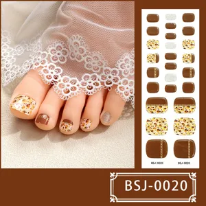 Semi-geharde gel teennagelstickers met bruine luipaardprint, kettingen en glitterontwerp.