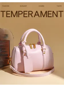 Pink leather Boston bag, chic pillow style handbag with top handle and crossbody strap.