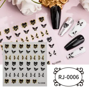 Detailed view of 5D embossed black and gold butterfly heart nail stickers and finished nail art.