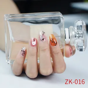 Primo piano dettagliato di adesivi per unghie con glitter sfumati e margherite brillanti.