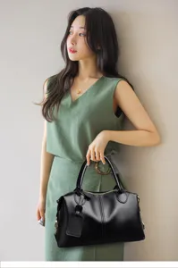 Vue rapprochée du sac à main Boston en cuir noir texturé au design élégant de coussin.