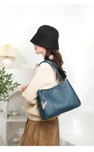 Detail shot of stylish blue leather shoulder bag with chic pendant and elegant design for commute.