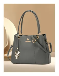 Detail view of the gray lychee grain shoulder handbag with gold hardware and flower charm.