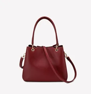 Red litchi grain women handbag detail showing premium leather texture and metal rings hardware.