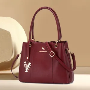 Burgundy litchi grain leather handbag with top handles and shoulder strap for women.