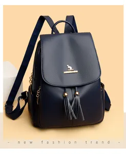 Dark blue leather backpack with tassel charms, stylish women's casual school bookbag with gold hardware.