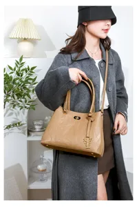 Fashionable women's handbag with debossed letters and metal pendant, perfect for daily commuting.