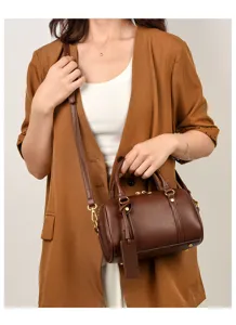 Stylish solid brown leather Boston bag, chic minimalist pillow handbag with crossbody strap.