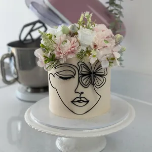 Minimalist abstract female face acrylic cake topper with butterfly and floral decor for parties.