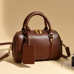 Dark brown leather Boston handbag for women, stylish crossbody pillow bag with top handle.