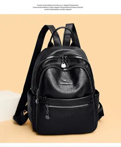 Detail view of black vintage oil wax leather backpack, dual zippers, pockets, and metal logo.