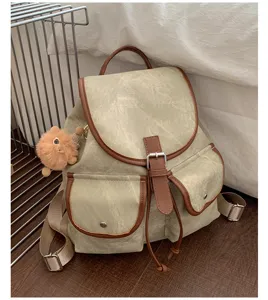 Casual canvas backpack for women with brown trim, dual front pockets and stylish drawstring design.