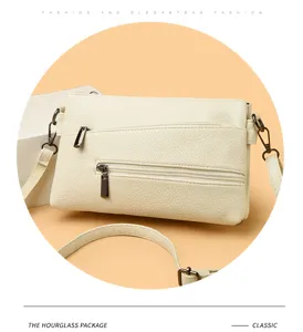 Classica borsa a tracolla in pelle crema con comode tasche con zip e design elegante.