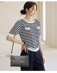 Graue Umhängetasche aus Leder mit zwei Frontreisverschlüssen, elegante Damenhandtasche.