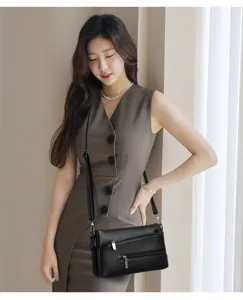Vista dettagliata della borsa a tracolla in pelle nera con tasche con zip e una finitura elegante.
