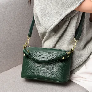 Green crocodile pattern leather crossbody handbag with gold hardware and top handle for women.
