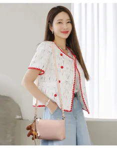 Detailansicht der stilvollen rosa Leder Umhängetasche mit süßem Pferdeanhänger und Jacke.
