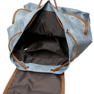 Casual denim backpack for women with brown leather trim, drawstring closure and inner pocket.