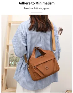 Detailansicht einer stilvollen braunen Nylorumhängetasche mit mehreren Taschen und Gurt.